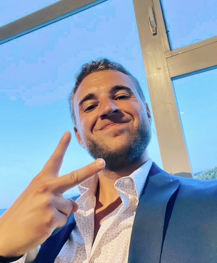 Brian now, healthy, grinning in a suit and making a peace sign